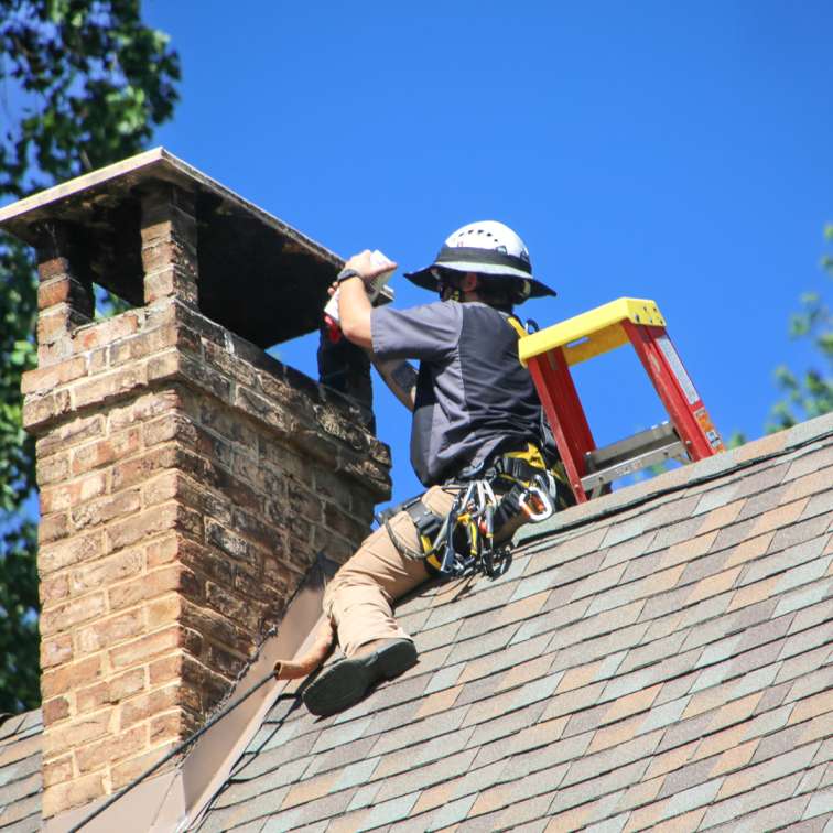 Technician repairing a leaking chimney in Woonsocket home