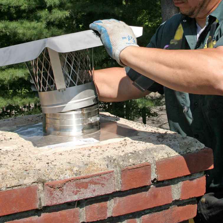 Certified chimney technician replacing a chimney cap in Warwick