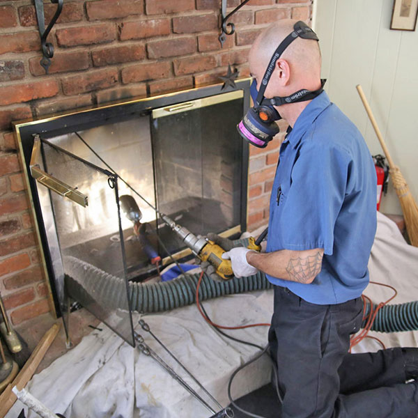 Technician fixing chimney draft problem in Woonsocket home